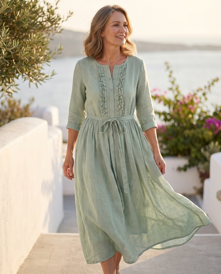 Model wearing the Karynthe dress on a sunlit coastal terrace