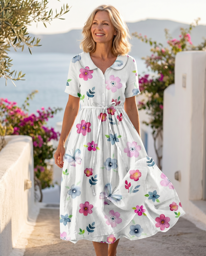 Model wearing the Olyndrah dress on a sunlit coastal terrace